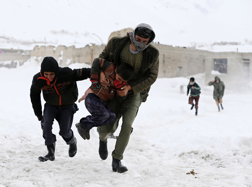 Afghan survivors of an avalanche run to get relief goods distributed by an Afghan army helicopter in the Paryan district of Panjshir