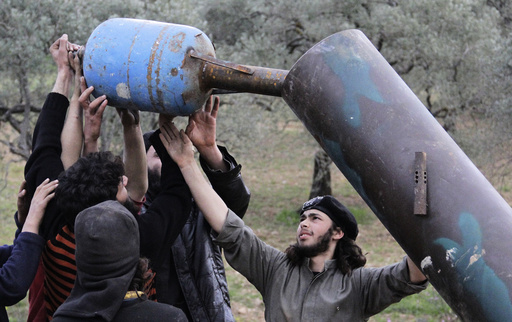 Rebel fighters from Suqour al-Sham Brigade prepare a locally made shell before launching it towards forces loyal to Syria's president Bashar Al-Assad in Idlib countryside