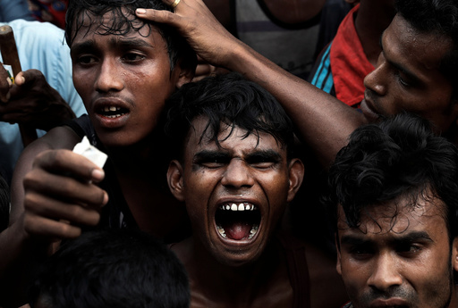 Rohingya refugees scuffle as they wait to receive aid in Cox's Bazar