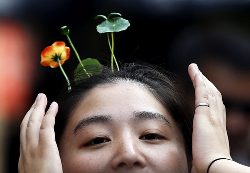 A woman wearing hairpins in the shape of sprouts and flowers makes her way on Nanluoguxiang street in Beijing