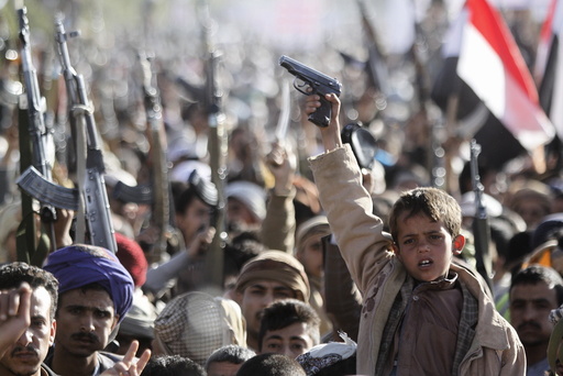 A boy shouts slogans as he raises a gun during a rally against U.S. support to Saudi-led air strikes, in Yemen's capital Sanaa