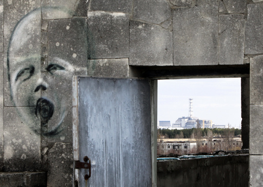 The sarcophagus covering the damaged fourth reactor at the Chernobyl nuclear power plant is seen behind a building in Prypiat