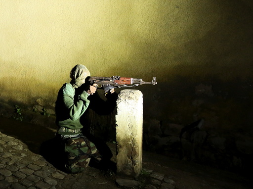 An armed vigilante holds an AK-47 rifle in the center Bujumbura, Burundi