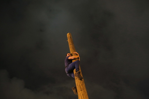A man climbs up a wooden pole during Maslenitsa celebrations at Gorky park in Moscow