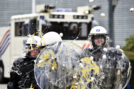 Policemen are hit by eggs as farmers and dairy farmers from all over Europe take part in a demonstration in Brussels