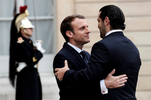 French President Emmanuel Macron and Saad al-Hariri, who announced his resignation as Lebanon's prime minister while on a visit to Saudi Arabia, embrace in the courtyard of the Elysee Palace in Paris