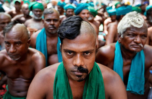 Farmers from the southern state of Tamil Nadu pose half shaved during a protest demanding a drought-relief package from the federal government, in New Delh