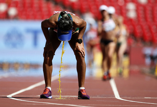 Cisiane Lopes of Brazil vomits after competing in the women's 20 km race walk final during the 15th IAAF World Championships at the National Stadium in Beijing,