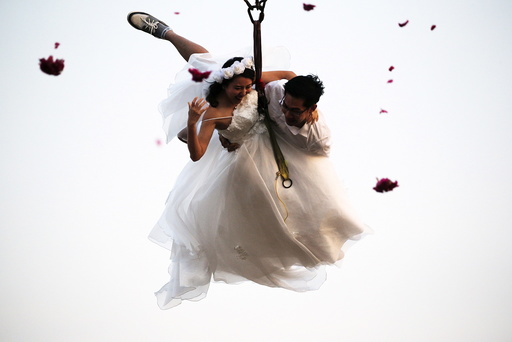 Bride Duangreuthai and groom Kasemsak fly while attached to cables during a wedding ceremony ahead of Valentine's Day at a resort in Ratchaburi province
