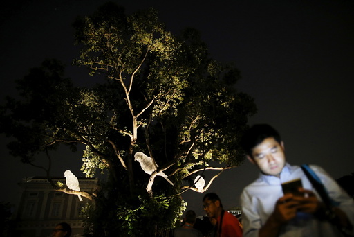 People walk past an art installation of three bird sculptures, Le Desir Et La Menace, by French artist Cedric le Borgne during a media preview of the Singapore Night Festival in Singapore