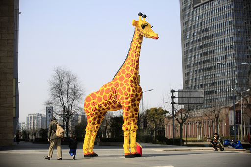 A 6.16-meter tall Lego giraffe is seen next to a shopping mall in Shanghai