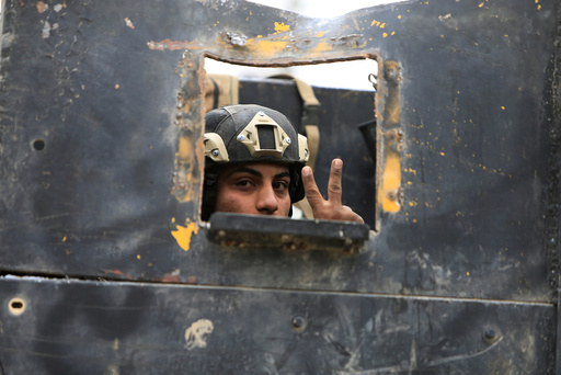 A member of the Iraqi Special Operations Forces (ISOF) gestures in military vehicle during a battle with Islamic State militants in Mosul