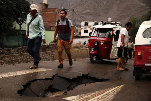 People walk after a landslide and flood in Chosica, east of Lima.