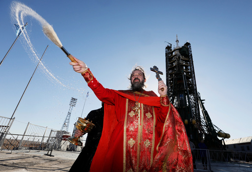 An Orthodox priest conducts a blessing in front of the Soyuz MS-04 spacecraft set on the launchpad at the Baikonur cosmodrome