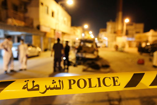 Police and crime scene officials are seen near scene where a blast killed one and seriously injured two police officers in the village of Diraz west of Manama